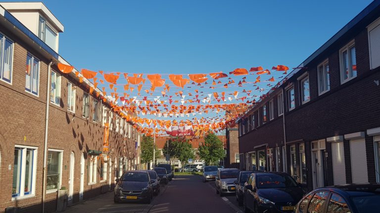 Goudse straat versierd met oranje vlaggetjes tussen de huizen