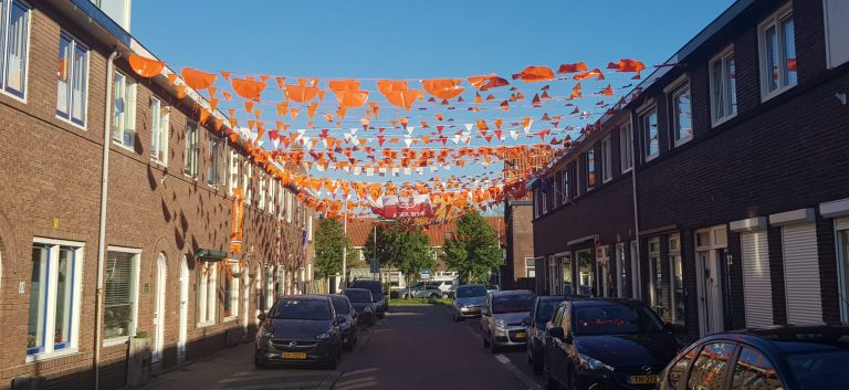 Goudse straat versierd met oranje vlaggetjes tussen de huizen