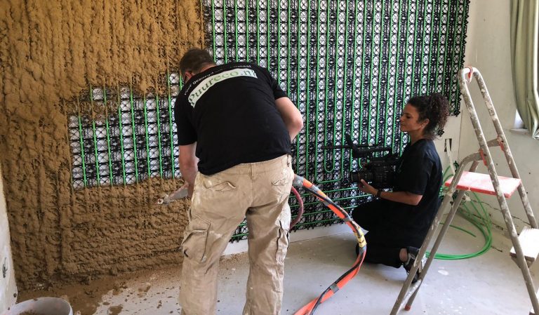 2 werknemers van Puureco brengen folie en muurverwarming aan in een muur.