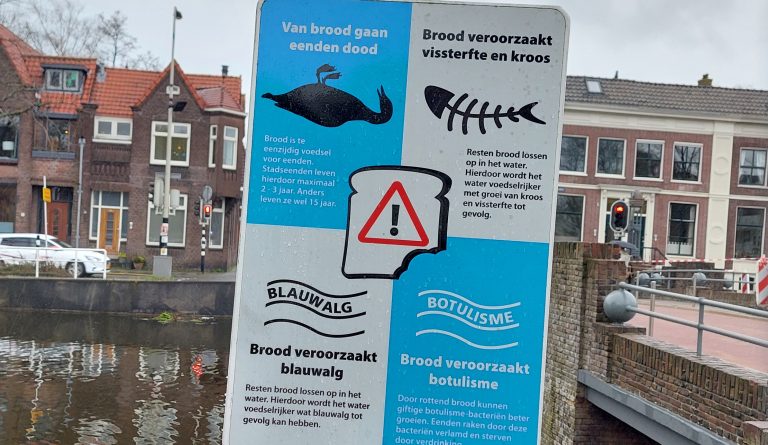 Een bord met waarschuwingen om de eenden niet te voeren, langs het kanaal