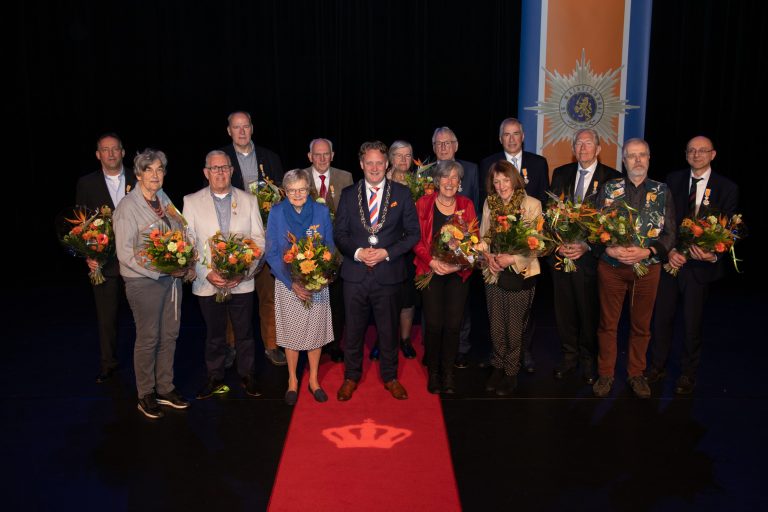 Op de foto staan alle gedecoreerden samen met burgemeester Pieter Verhoeve.