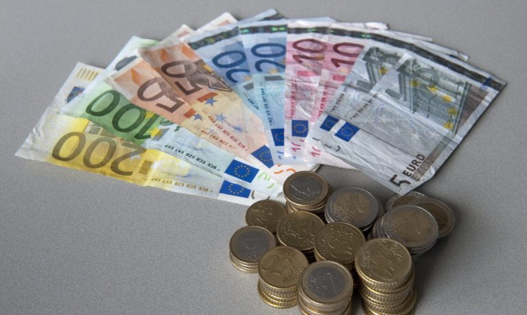 Een hoeveelheid euro biljetten (van 5, 10, 20, 50, 100 en 200) en een stapel euromunten.