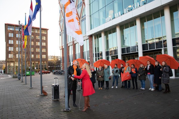 Wethouder Anna van Popering-Kalkman hijst de vlag van ‘Orange the World’ bij het Huis van de Stad, zij deed dat vorig jaar.
