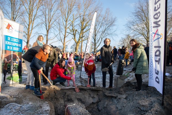 Kinderen van basisscholen De Triangel en Auris Taalplein stoppen samen met wethouder onderwijs Thierry van Vught een tijdcapsule in de grond.