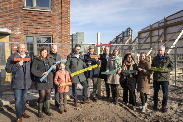 Op de foto ziet u wethouder Jan Kees Oppelaar met huurders van het nieuwbouwproject op het bouwterrein.