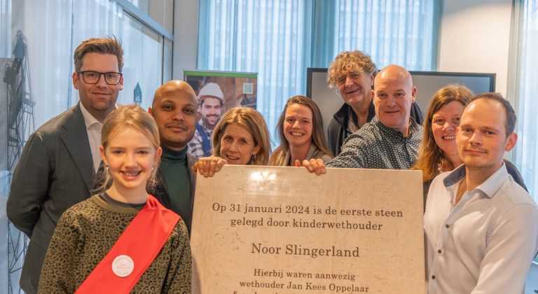 Wethouder Jan Kees Oppelaar en kinderwethouder Noor Slingerland met plaquette bij woningbouwproject Wonen in Goud