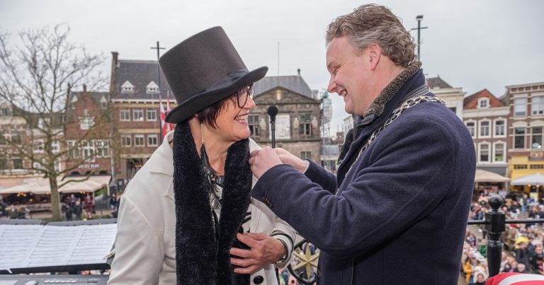 Ereburger Irene Klein Haneveld krijgt van burgemeester Pieter Verhoeve de erepenning opgespeld.