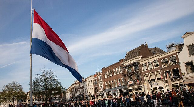 De foto laat zien dat de Nederlandse vlag halfstok hangt op de Markt in Gouda.
