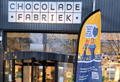 Op de foto is een banner te zien van het spreekuur van de boa's. Deze banner staat naast de ingang van de Chocoladefabriek.