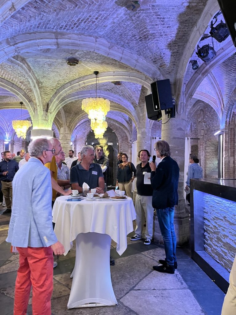 De foto is genomen in de burgerzaal van het stadhuis op de Markt. Rachts staat wethouder Thierry van Vugt, die een toespraak houdt. Verder op de foto bezoekers van het evenement die aan statafels staan.