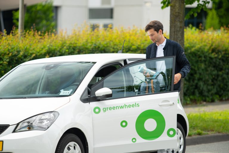 Man stapt in een deelauto van het bedrijf Greenwheels.