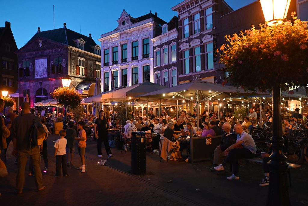 Foto van mensen op de terrassen op de Markt in de avond