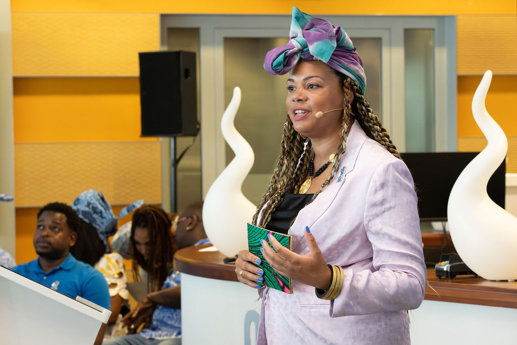 Moderator Mahutin Awunou spreekt in de hal van het Huis van de Stad.