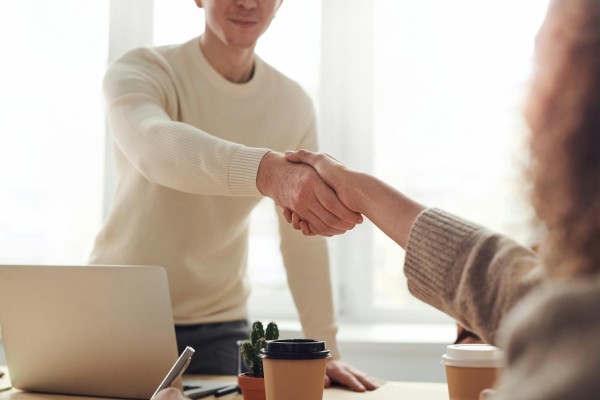 Twee mensen geven elkaar een hand