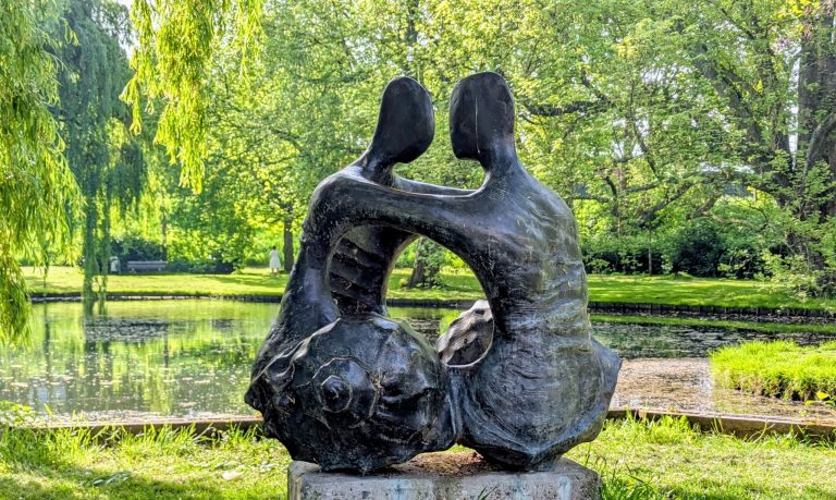 Op de foto is het beeld van de bekende kunstenares Maja van Hall-Blom te zien. Het kunstwerk bestaat uit twee personen die elkaar vasthouden, met een schelp als onderlichaam.