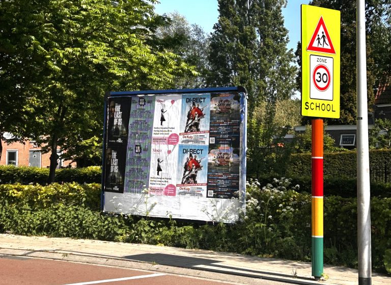 Een bord waarop iedereen stickers, affiches en posters mag plakken.