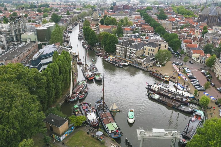 Dit is een foto van de museumhaven in Gouda met schepen in het water