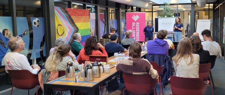 Een bijeenkomst over inclusief Gouda, waar 2 sprekers een groepje mensen toespreken.