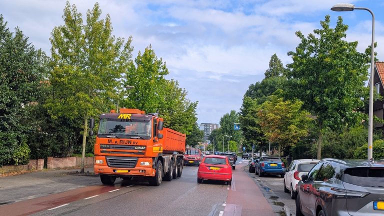 Een blik op de Koningin Wilhelminaweg met auto's en vrachtverkeer.