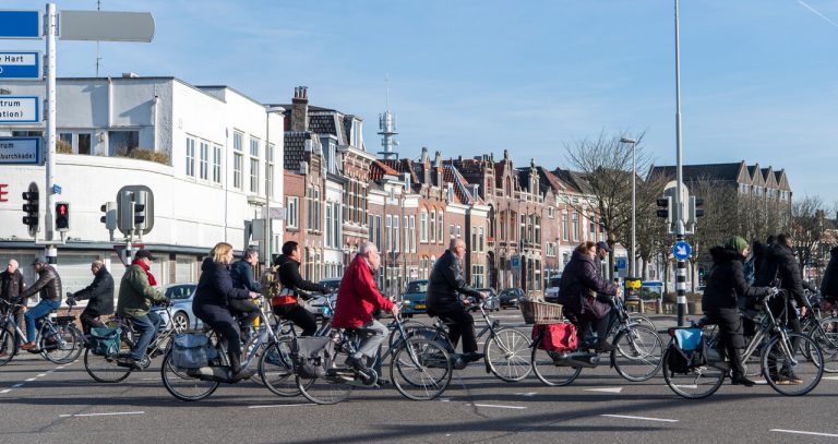 Een groep fietsers steekt een kruispunt over.