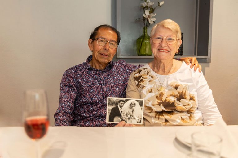Foto van een echtpaar met een huwelijksfoto van 60 jaar geleden.