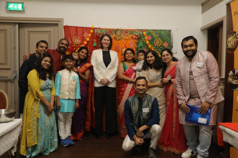 Mensen in Indiase kleding poseren met wethouder Ineke Schaddelee