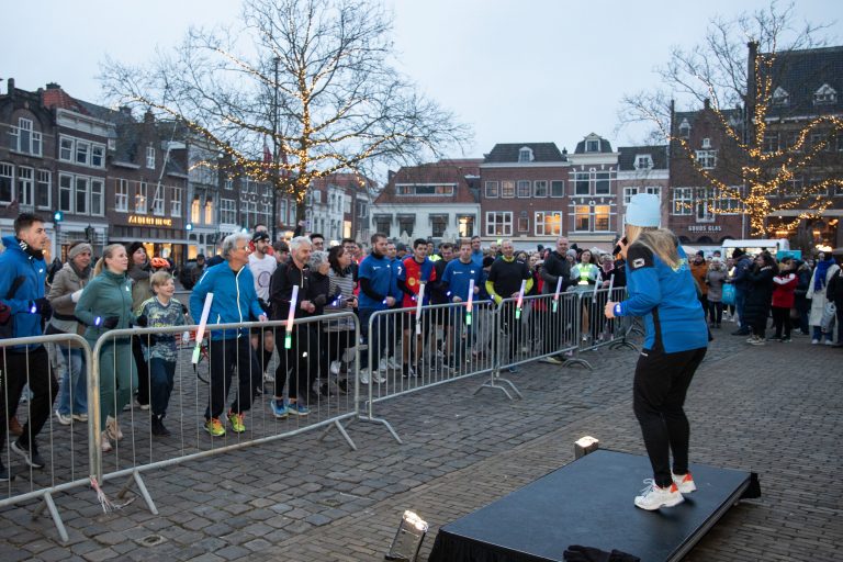 Een dame staat voor een menigte de deelnemers toe te spreken.