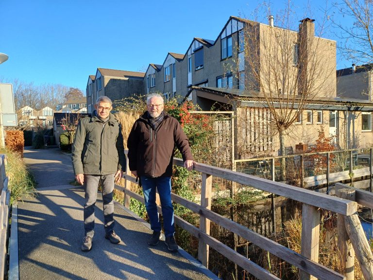 Paul en Jan poseren op een bruggetje.