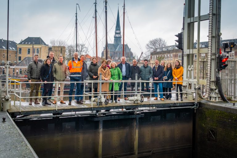 Foto van de Mallegatssluis met op de brug wethouder Judith Sargentini en projectleiders van alle betrokken organisaties.