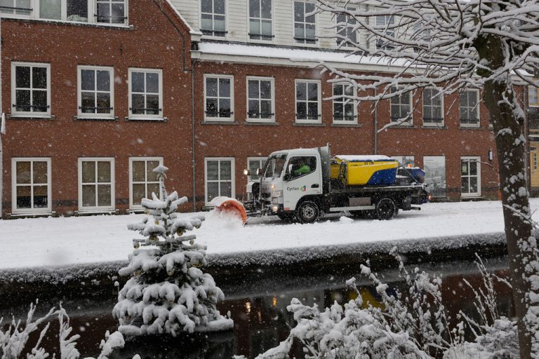Een sneeuwschuiver van Cyclus schuift sneeuw weg in de wijk