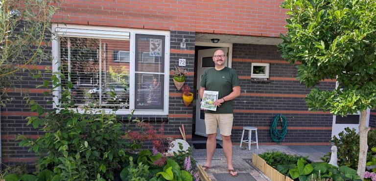 Koen Zijlstra staat in de deuropening van zijn huis. Op de foto is de groene voortuin duidelijk zichtbaar.