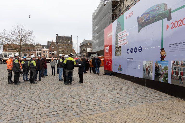 groep mensen die buiten op een plein staan