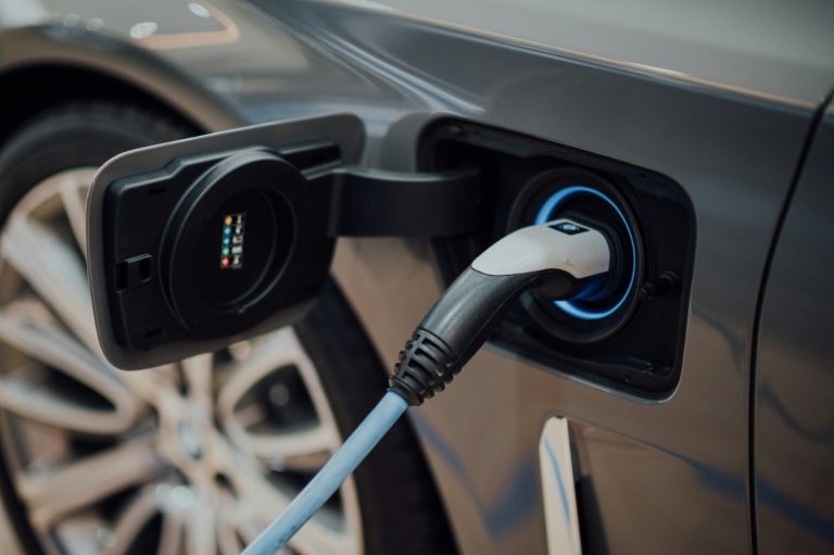 Close-up van een stekker in de een elektrische auto om te laden.